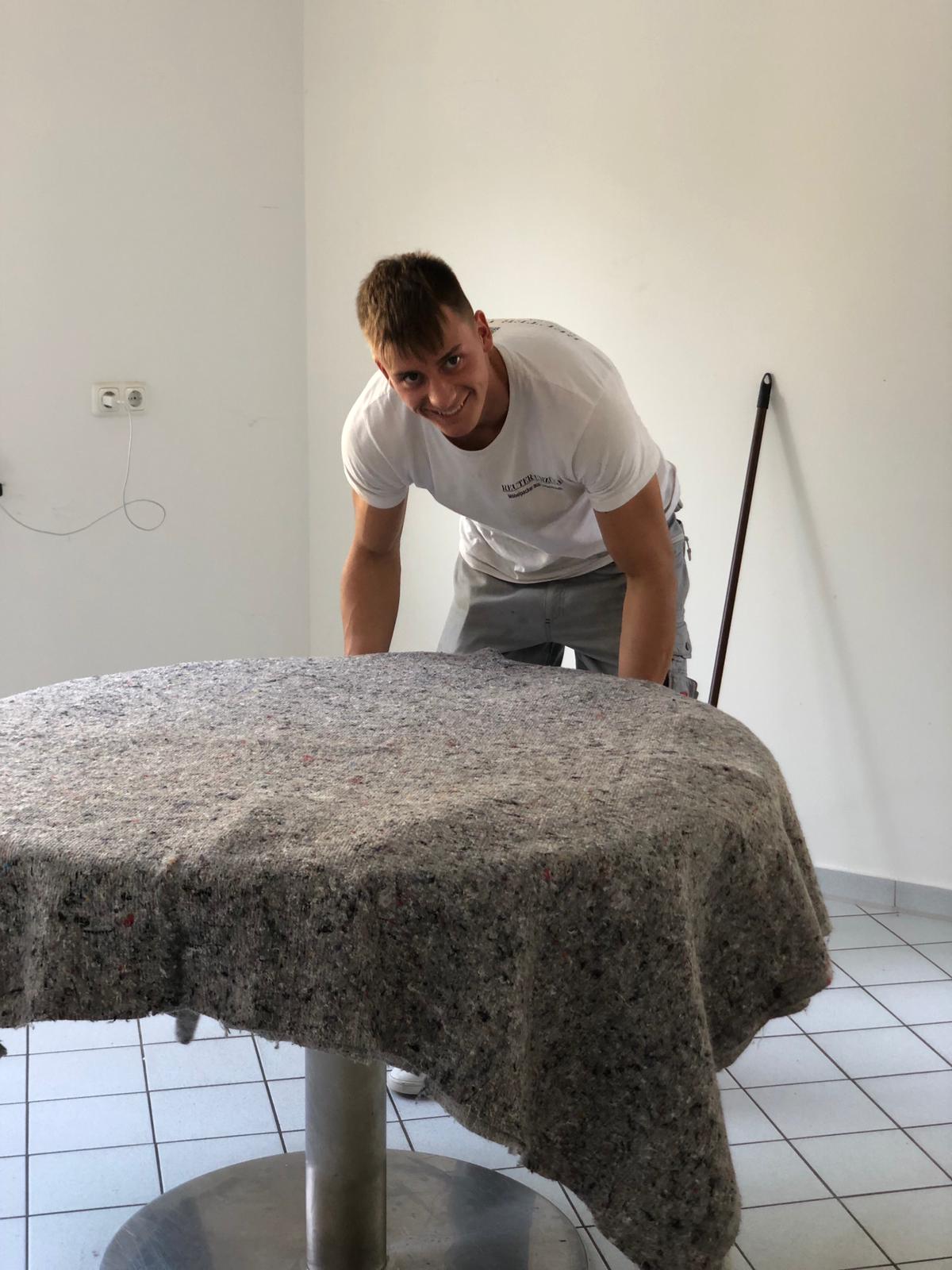 Ein Tisch wird von einem Reuter Umzüge Mitarbeiter sicher verpackt für eine Wohnungsaufloesung.