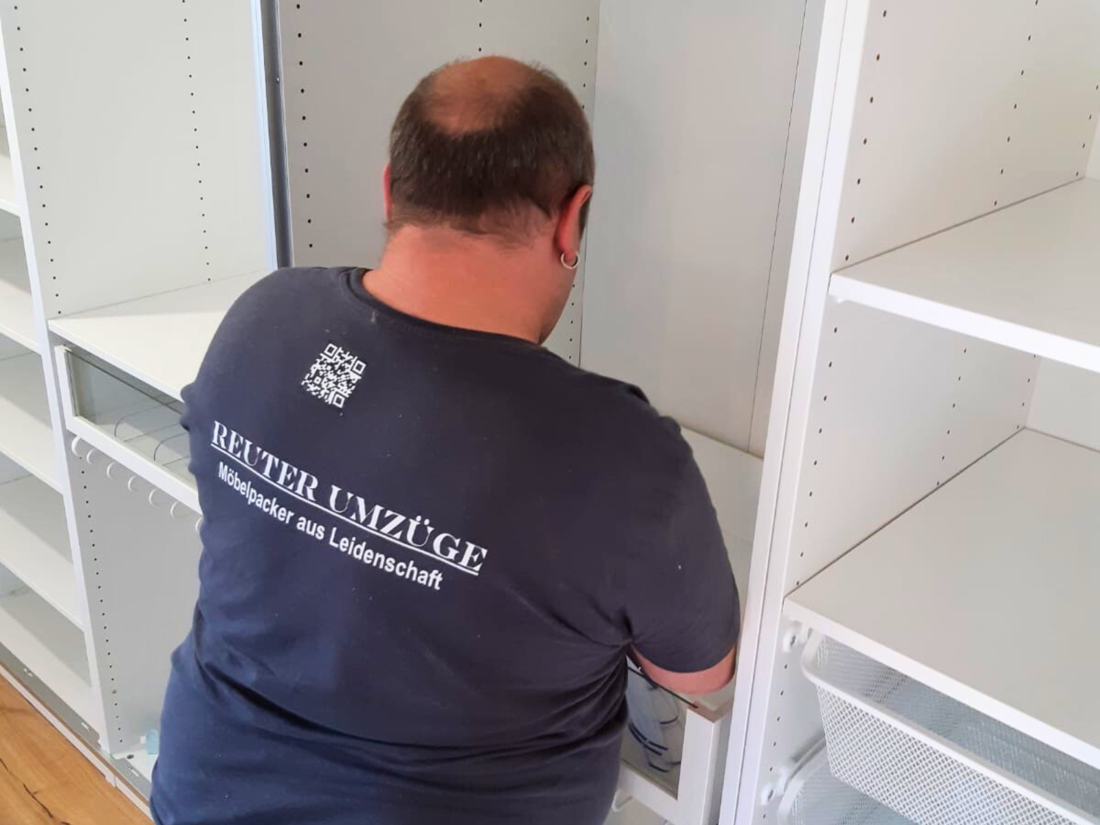 Unaufgeräumter Dachboden mit Kartons, alten Möbeln, Stuhl und Elektroverpackung unter dem Dachfenster – typische Ausgangssituation für eine Entrümpelung Köln.