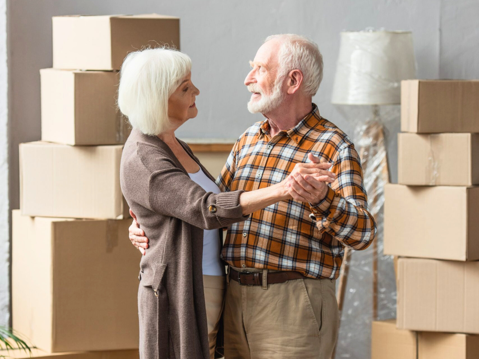 Unaufgeräumter Dachboden mit Kartons, alten Möbeln, Stuhl und Elektroverpackung unter dem Dachfenster – typische Ausgangssituation für eine Entrümpelung Köln.