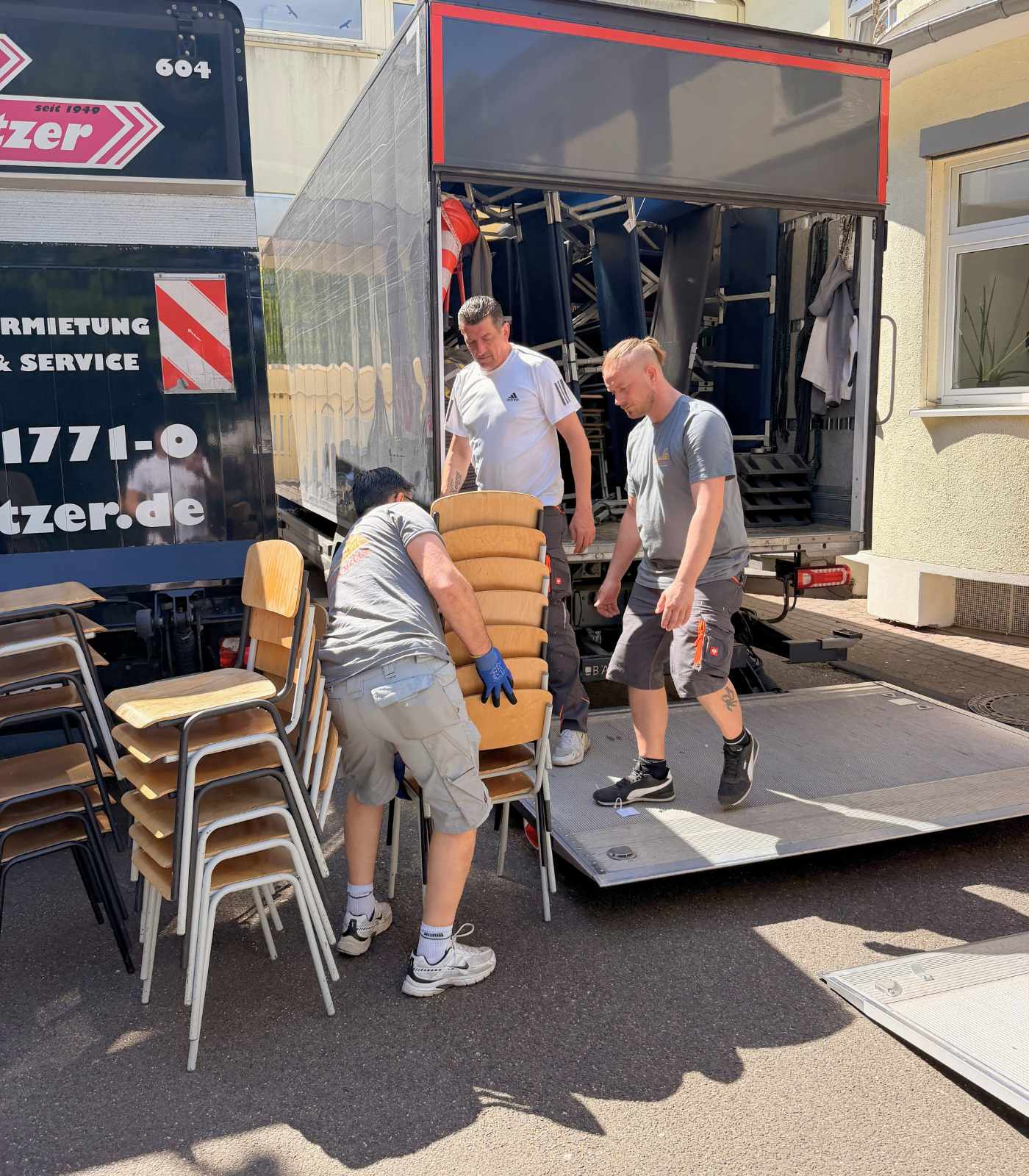 Das Team von Reuter Umzüge lädt gestapelte Stühle sicher in einen Umzugs-Lkw ein.