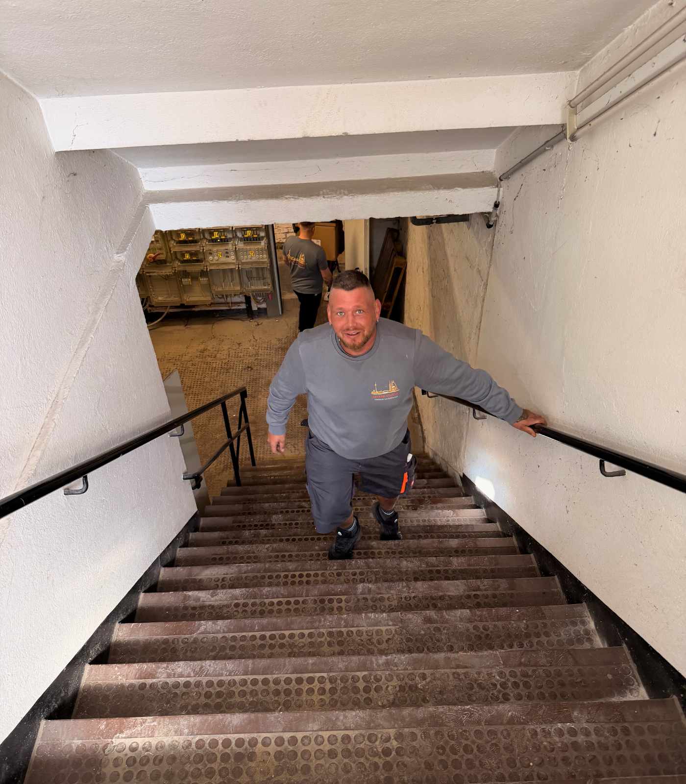 Ein Mitarbeiter von Reuter Umzüge transportiert Umzugsgut über ein Treppenhaus in einem Bürogebäude.